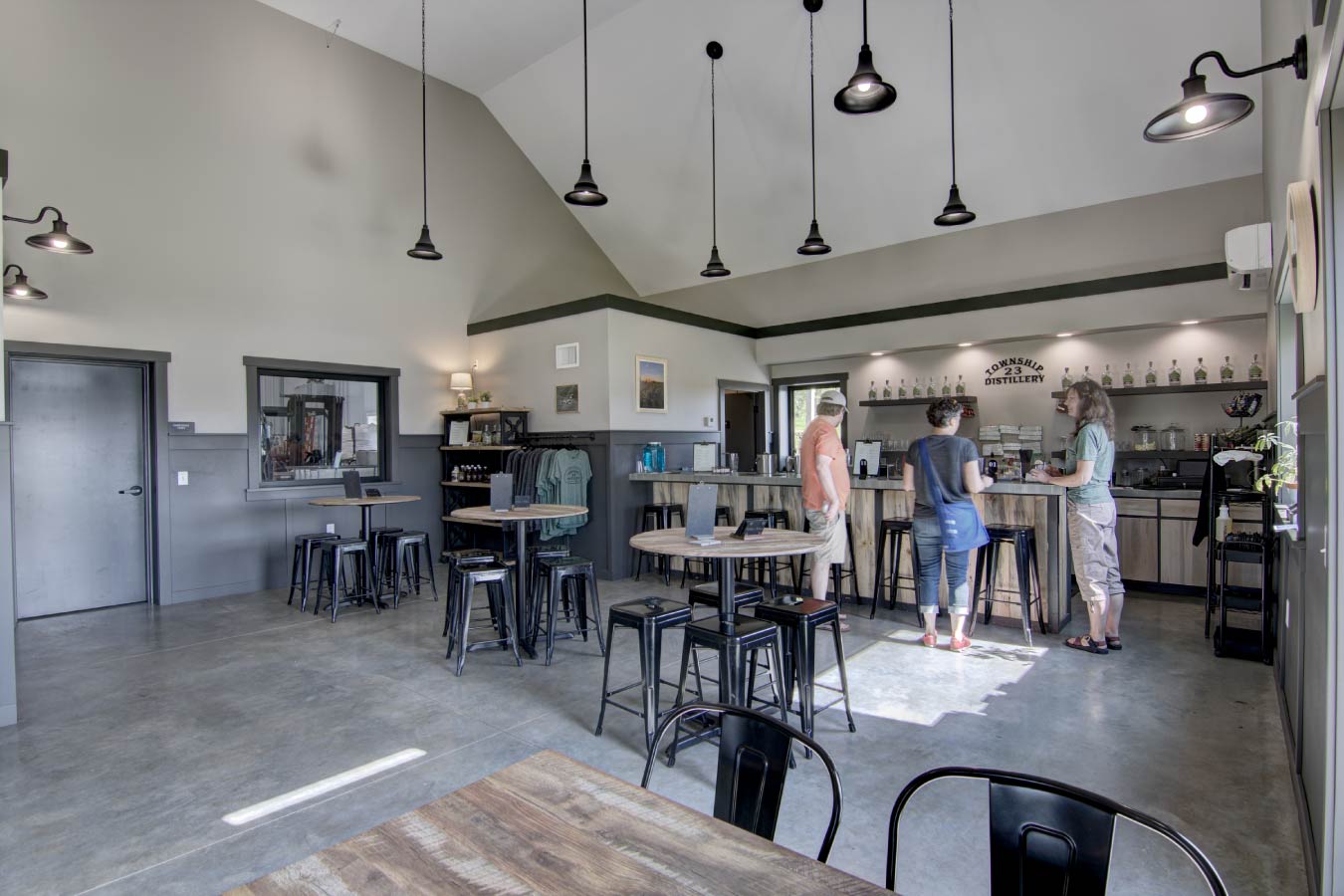 commercial building interior tasting room with bar seating merchandise display and polished concrete floors