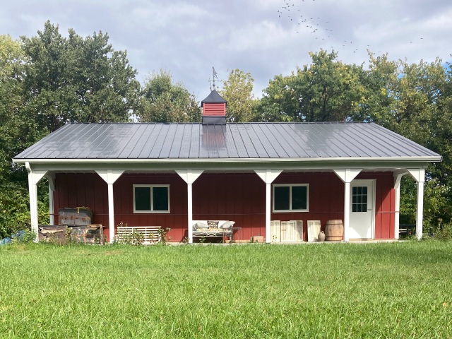 Post frame building with steel siding, covered porch, and cupola