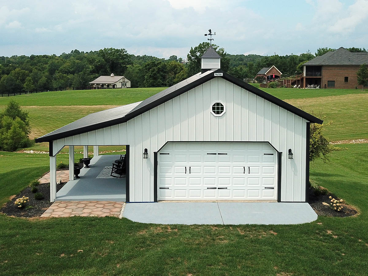 Post frame garage with steel siding, overhead door, cupola, and lean to porch