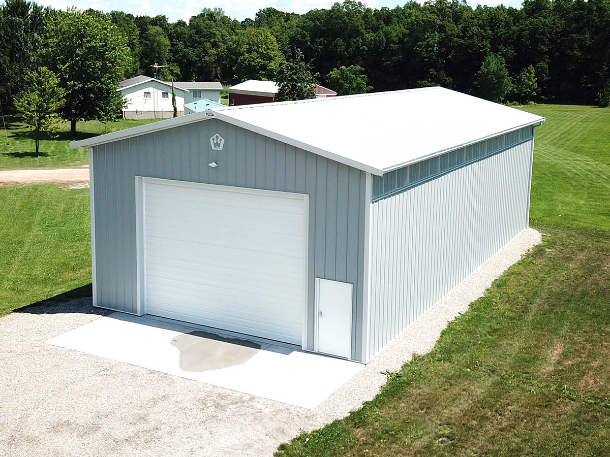 Post frame RV storage building with steel siding, large overhead door, and walk door