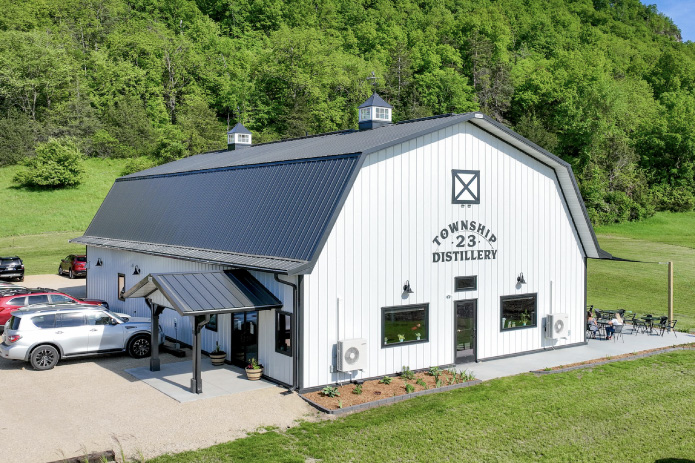 Commercial Building Distillery with Gambrel Roof and Covered Entrance – Walters Buildings commercial building distillery with black gambrel roof white steel siding cupolas and covered entrance canopy