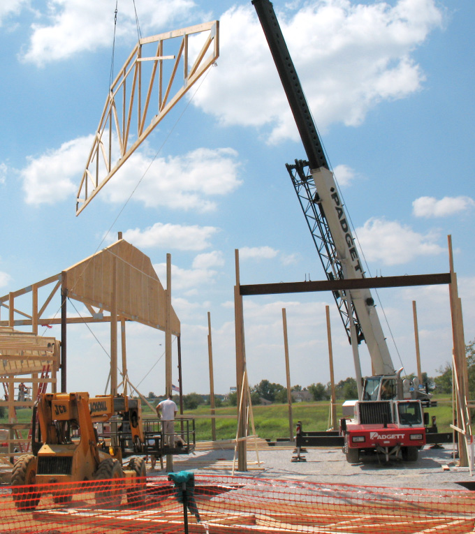 Walters Buildings construction crew installing roof trusses with crane during post-frame building process
