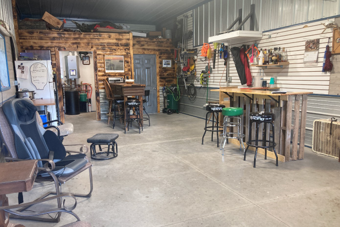 Lake House Garage Interior with Bar Area and Workshop Space | Walters Buildings Lake house garage interior with bar area, workshop space, and rustic wood accent wall