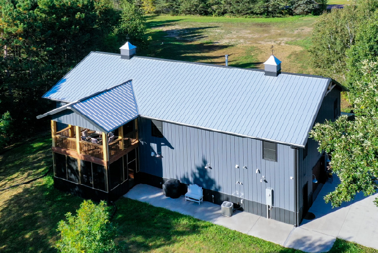 Luxury barndominium with screened porch and metal roof built by Walters Buildings