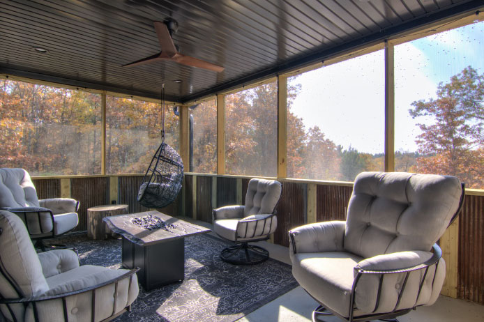 Barndominium Screened Porch with Outdoor Seating | Walters Buildings Barndominium screened porch with metal ceiling, ceiling fan, and outdoor seating area