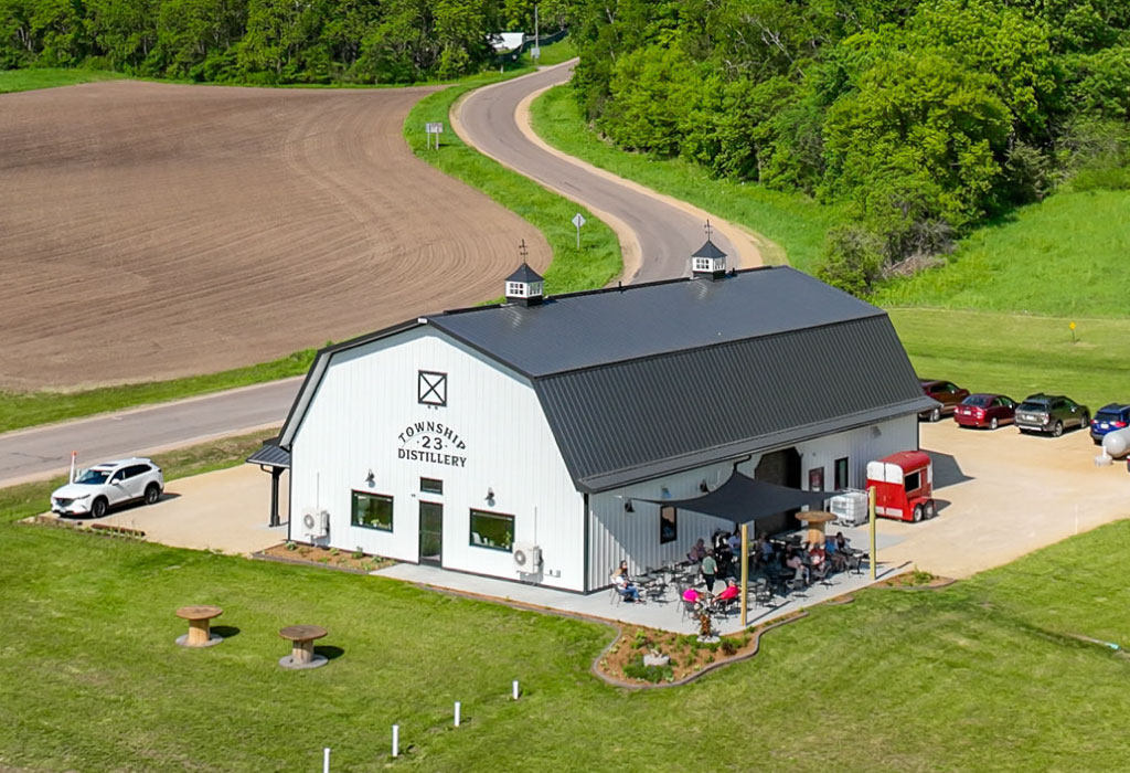 Commercial distillery building with steel siding, cupolas, and outdoor seating area