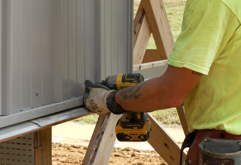 Walters Buildings crew installing steel siding with precision and professional construction process