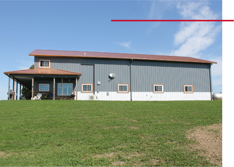 Pole barn house exterior with steel siding, metal roof, and covered porch