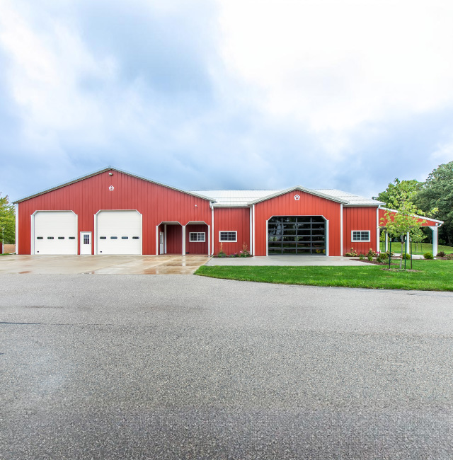 Red Pole Barn with Overhead Doors | Walters Buildings Red pole barn with white overhead garage doors and large glass garage door entrance