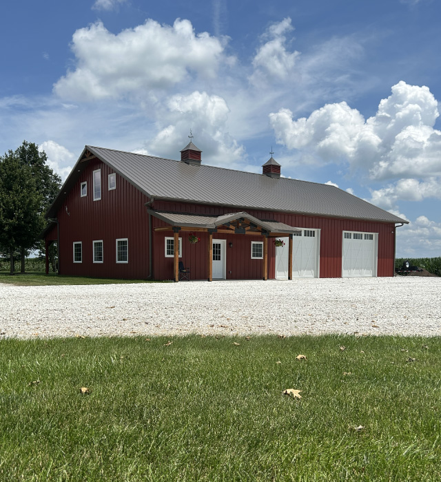 Residential Workshop with Red Steel Siding and Covered Porch | Walters Buildings Pole Barn Workshop in Auburn, Illinois Residential workshop with red steel siding, steel roof, overhead garage doors, Plyco windows, cupolas, and covered porch Pole Barn Workshop in Auburn, Illinois