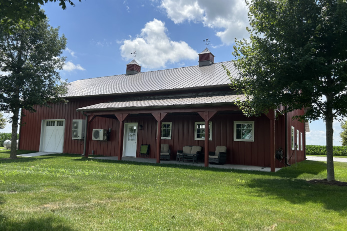 Residential Workshop with Covered Porch and Red Steel Siding | Walters Buildings Residential workshop with red steel siding, steel roof, covered porch, Plyco windows, and cupolas