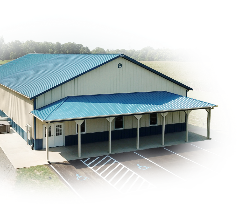 Steel commercial building with covered porch, parking lot, accessible spaces, and walk door entrance