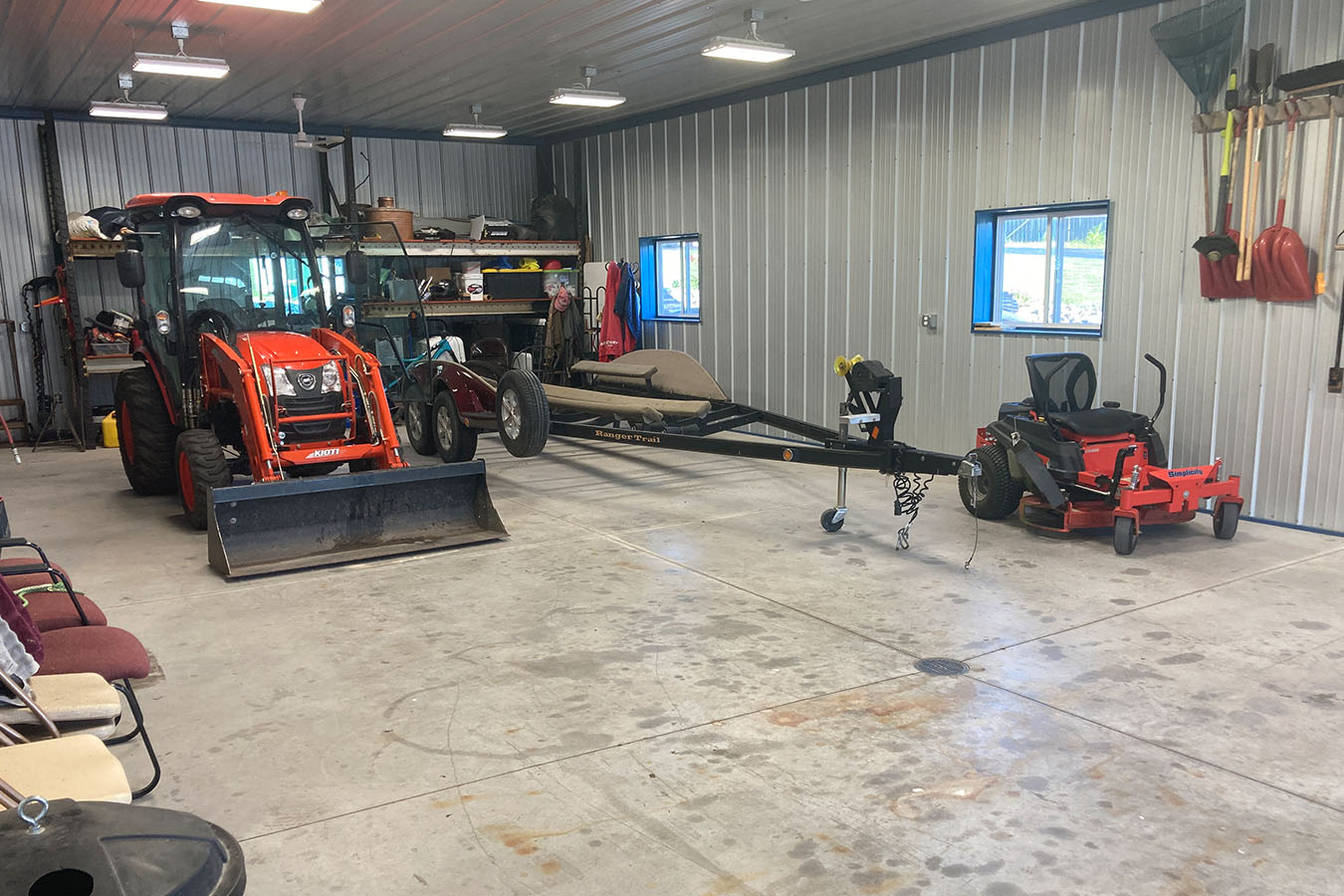 Lake house garage interior with tractor, mower, trailer, and steel liner walls