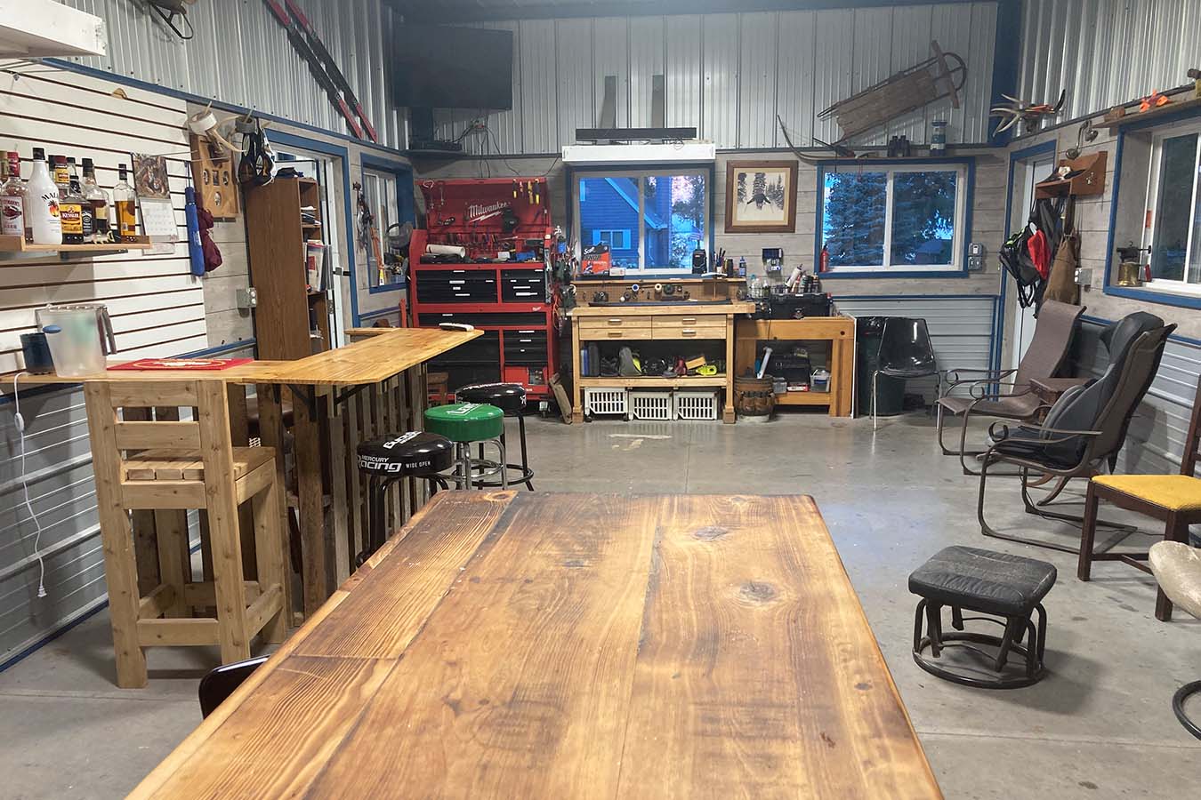 Lake house garage workshop with workbench, tool storage, and bar seating area