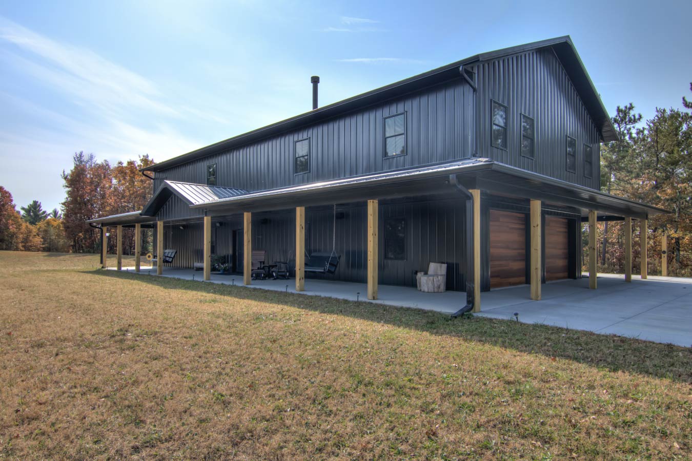 98-1505 36x72 barndominium with dark steel siding, wraparound porch, and attached garage