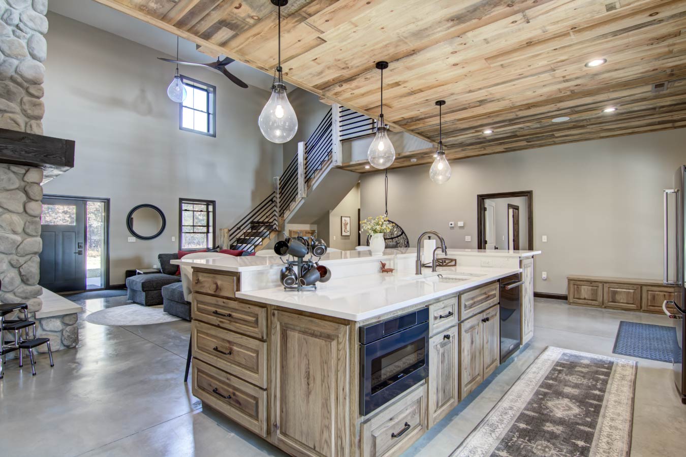 Barndominium kitchen with large island, wood ceiling, and open loft staircase Kitchen Island with Breakfast Bar