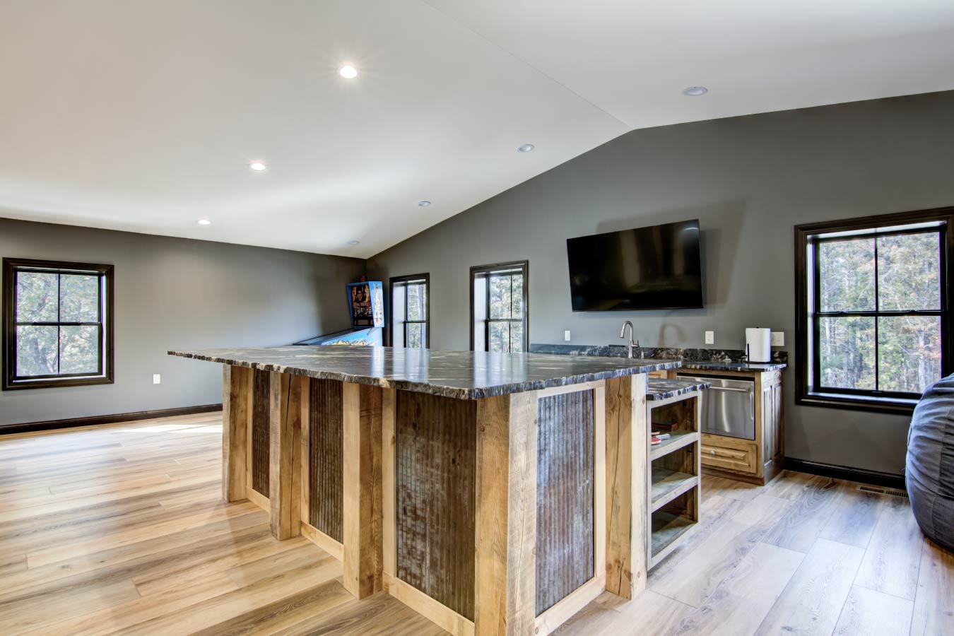 Barndominium loft bar with stone countertop and rustic wood panels