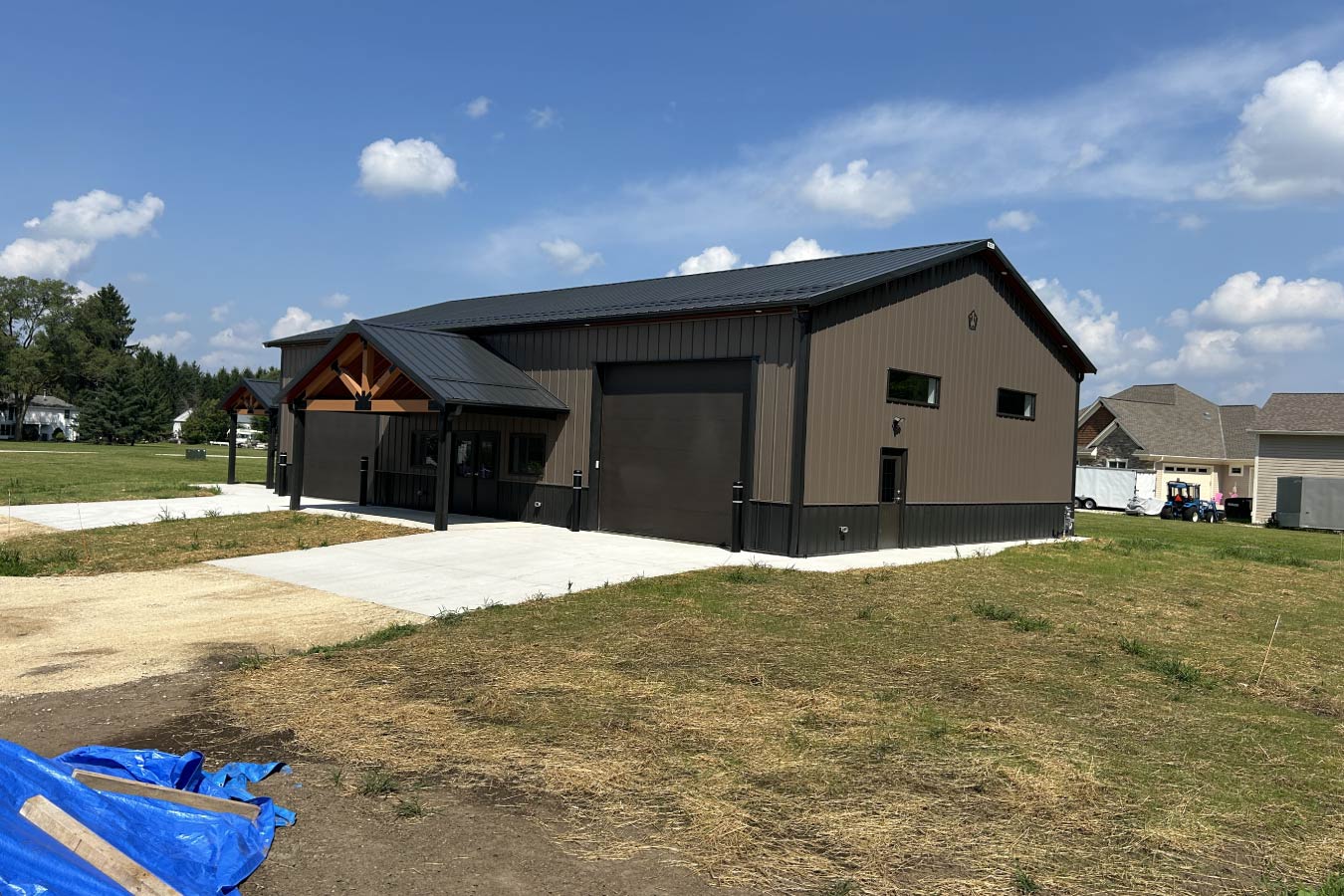 Gable entrance building with steel siding, steel roof, overhead door, and cedar truss entry