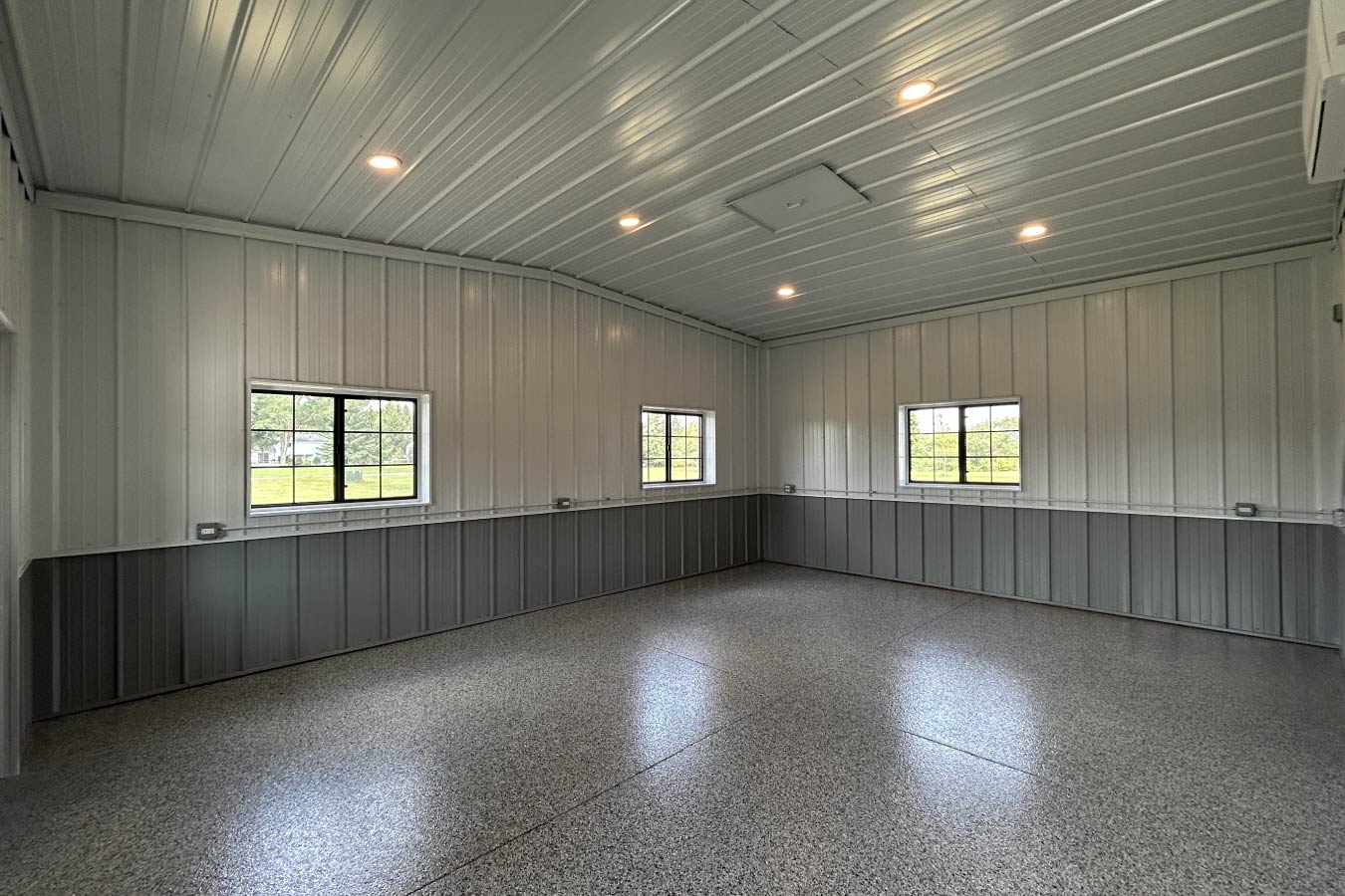 Finished interior of gable entrance building with epoxy floor, steel liner panels, and multiple windows