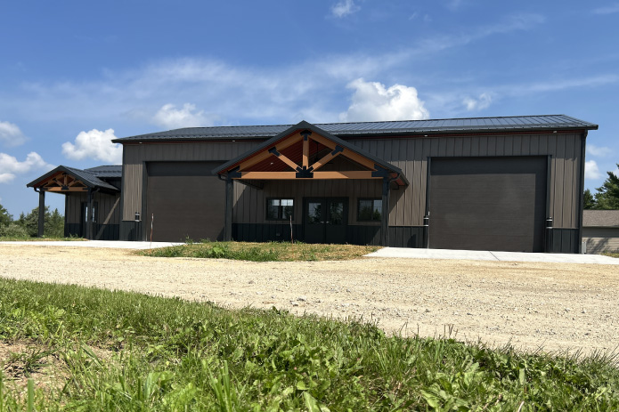 Gable Entrance Building with Timber Frame Porch and Overhead Doors | Walters Buildings Gable entrance building with timber frame porch, steel siding, and large overhead garage doors