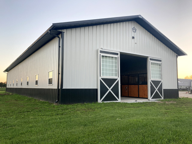 Allenton WI post-frame building by Walters Buildings with metal siding, overhead doors, and concrete driveway