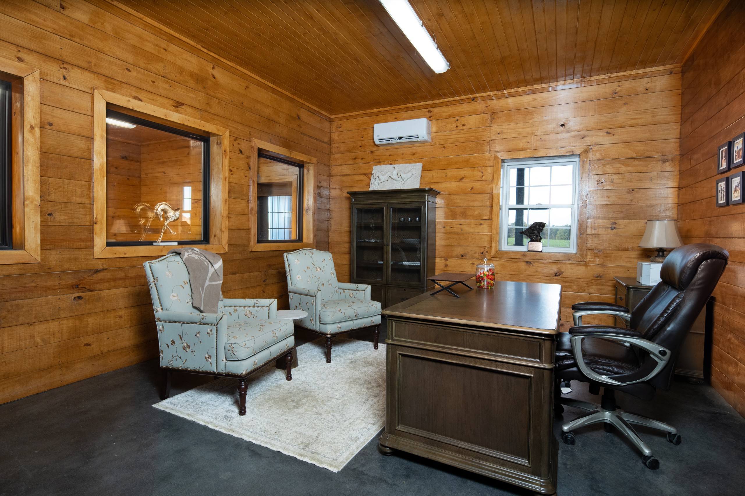Main office at The Settlement Equestrian Center with wood interior finishes, guest seating, and workspace for daily barn operations
