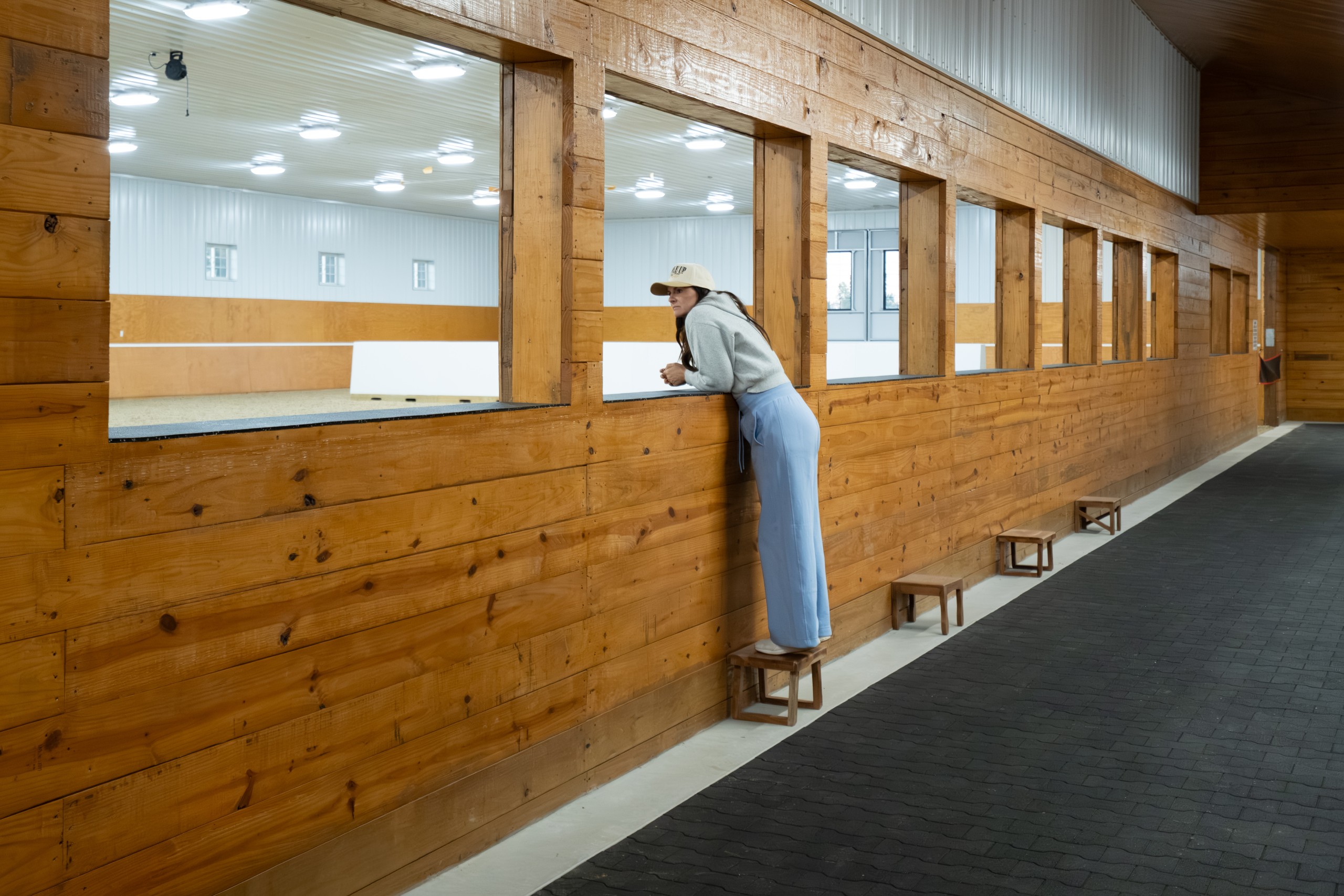 Viewing windows from the lobby hallway overlook the indoor riding arena at The Settlement Equestrian Center