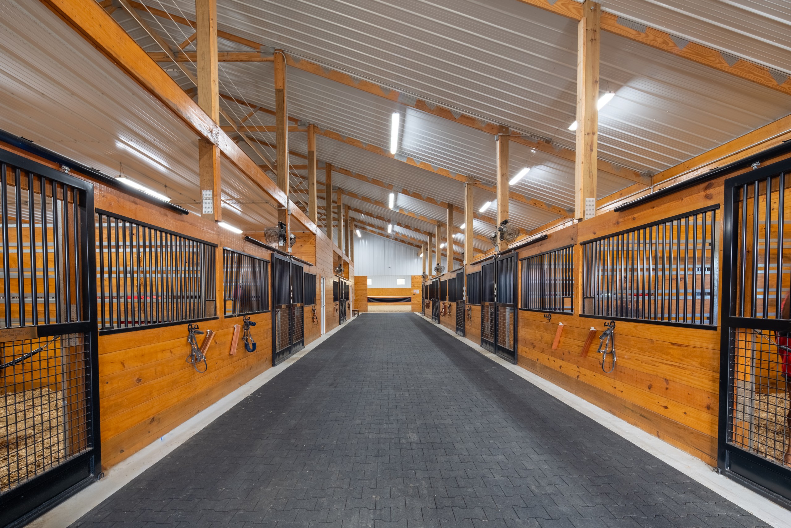 Stall Barn Interior at The Settlement Equestrian Center Interior aisle of the stall barn at The Settlement Equestrian Center with horse stalls and durable equine-ready finishes