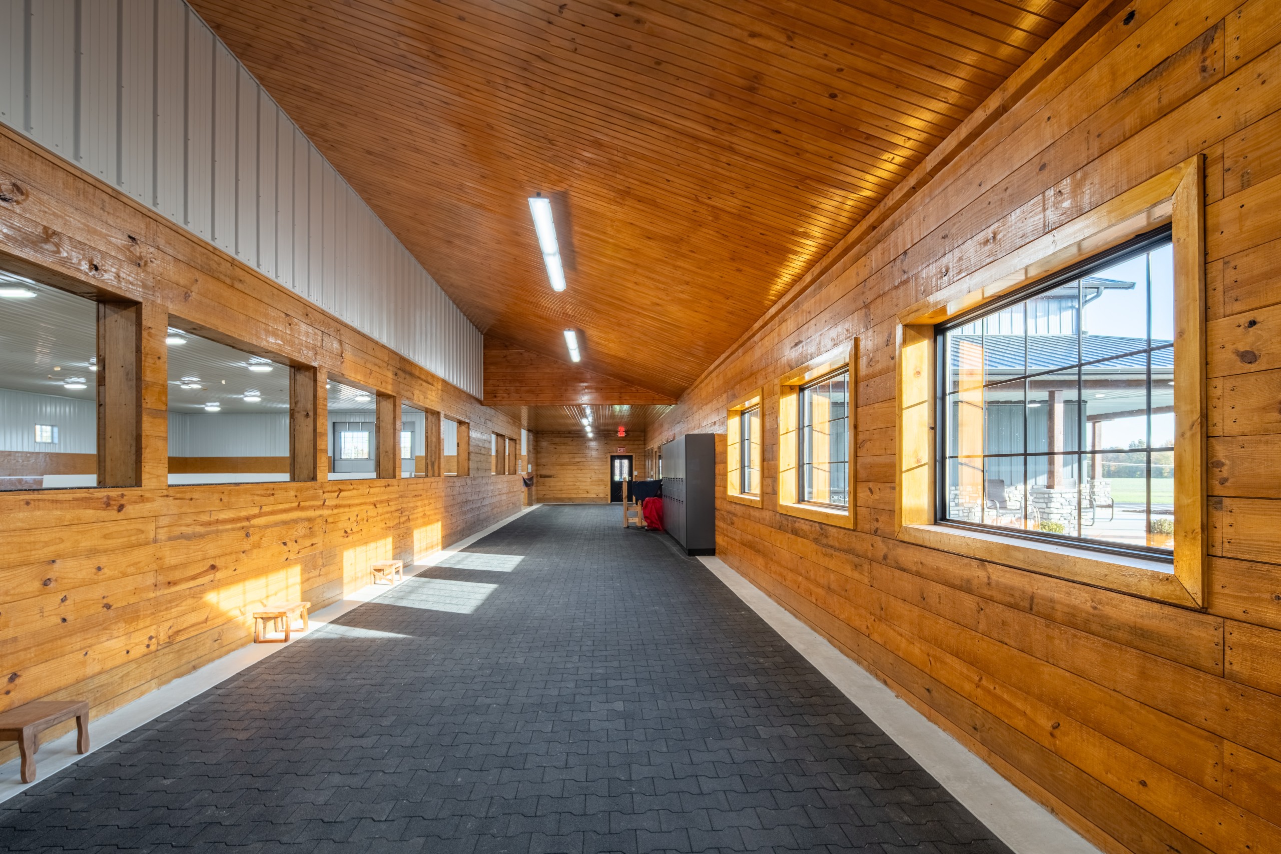 Finished hallway with arena viewing windows and exterior windows at The Settlement Equestrian Center