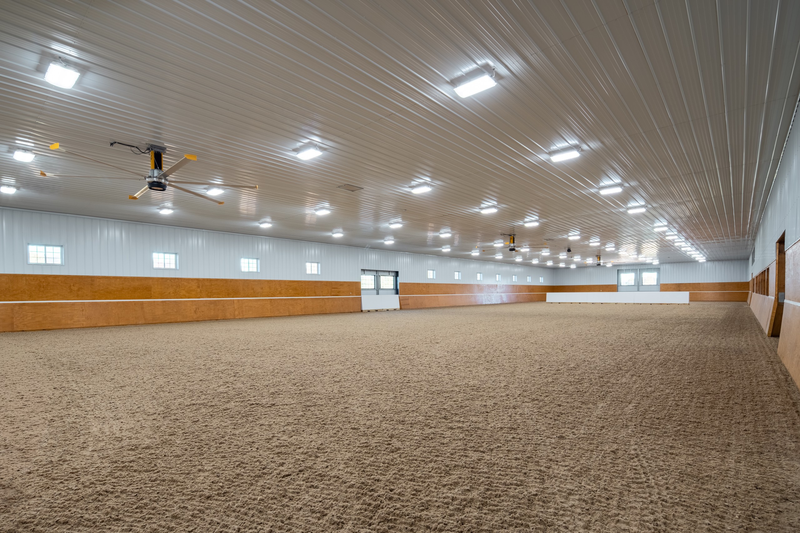 81' x 280' indoor riding arena at The Settlement Equestrian Center with tapered lower walls and clear-span equestrian training space