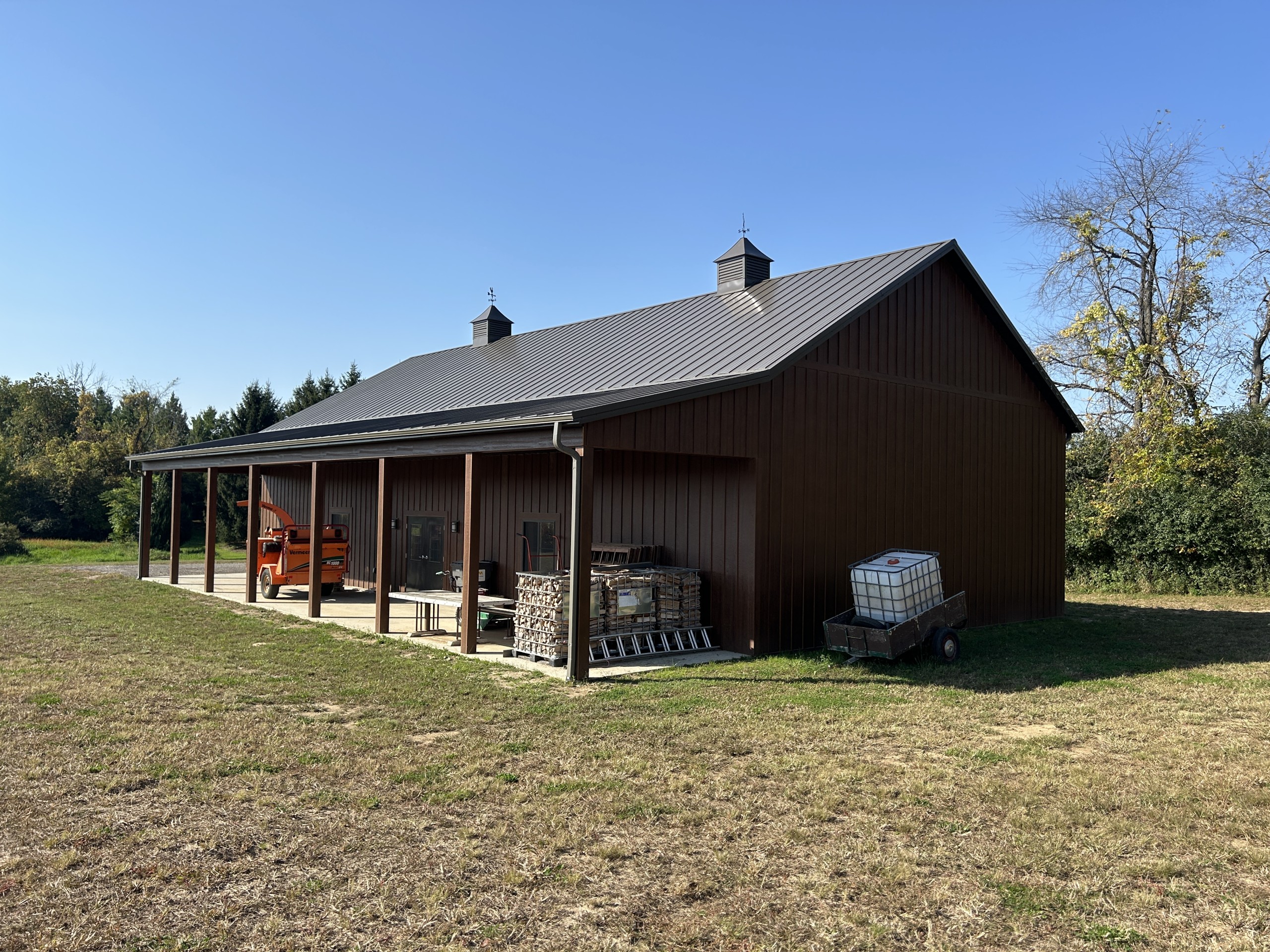 Side view of a 36' x 72' board and batten pole barn with a 12-foot porch and Burnished Slate roof