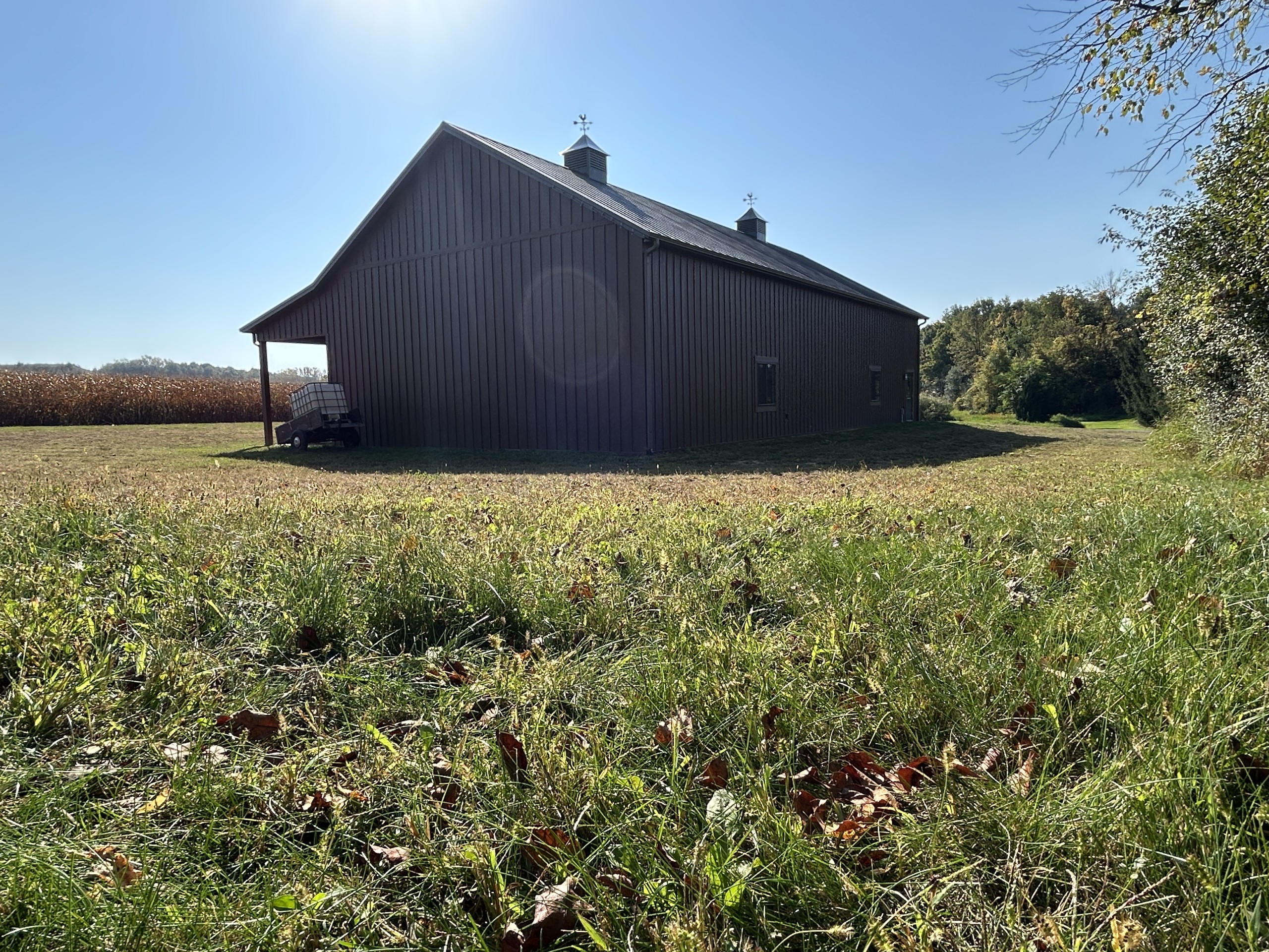 Side profile of a 36' x 72' board and batten pole barn with twin cupolas and Burnished Slate roof