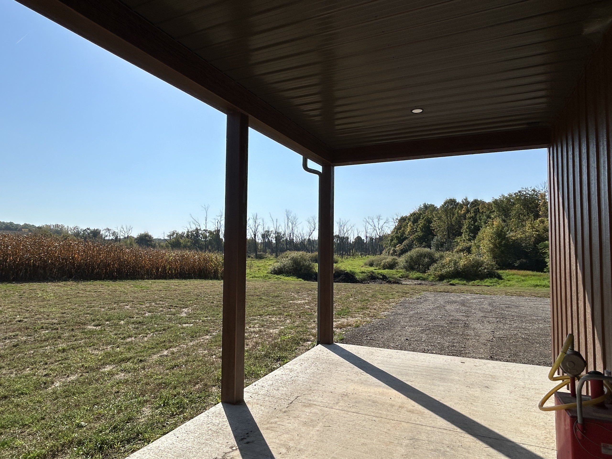 View from the side porch of a 36' x 72' board and batten pole barn overlooking the surrounding property