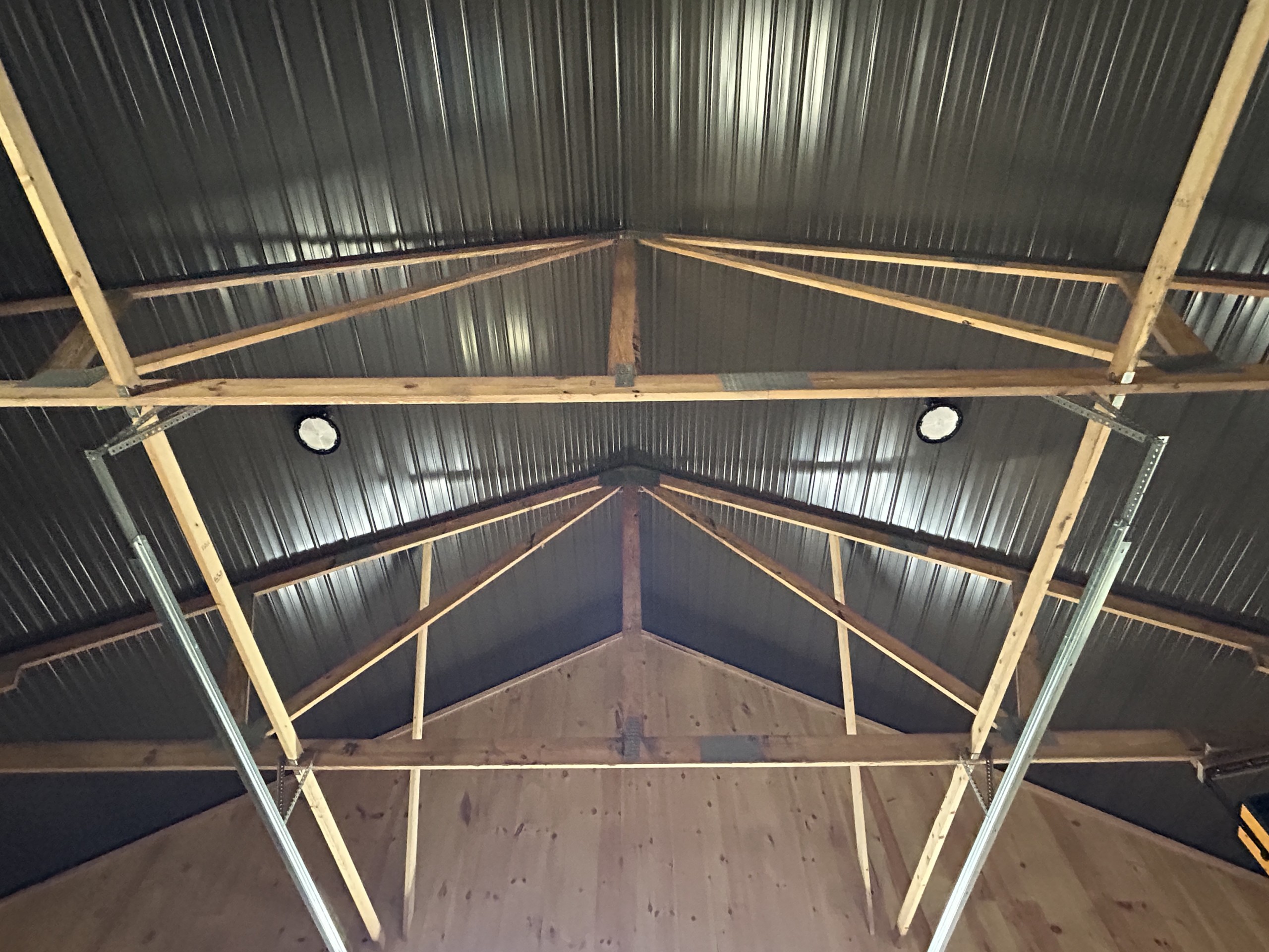 Burnished Slate steel ceiling panels between trusses inside a 36' x 72' board and batten pole barn