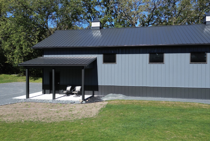 Gray and black 30×64 post frame garage exterior with overhead door, vertical metal siding, and modern windows Gray and black 30x64 post frame garage exterior with overhead door, vertical metal siding, and modern windows