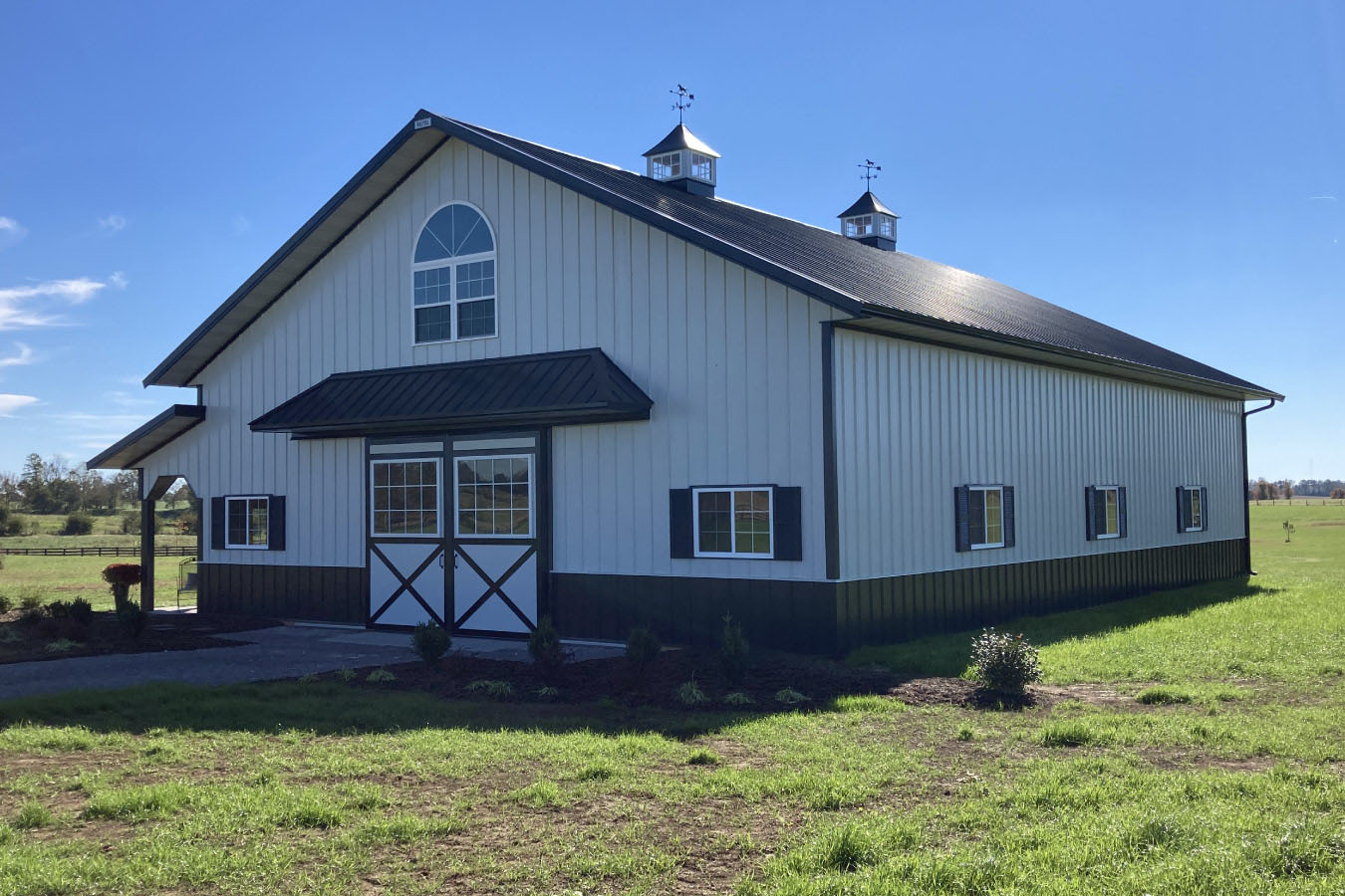 Angled view of 42x63 post frame workshop with large sliding doors and metal siding