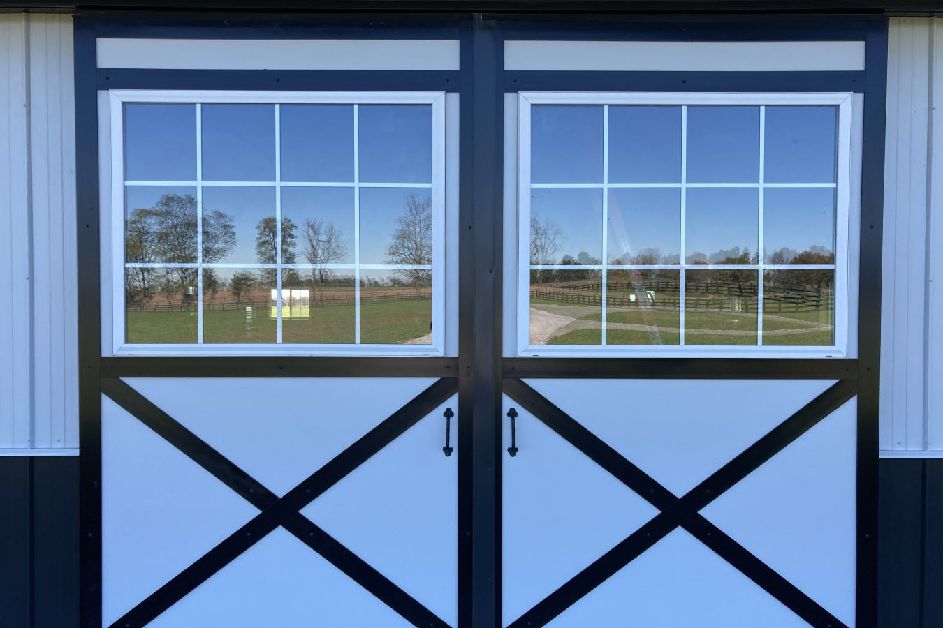 Wide view of 42x63x14 pole barn workshop with covered entry and landscaped surroundings