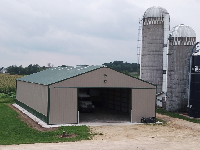 Custom post-frame building in Augusta Wisconsin with metal siding, overhead doors, and concrete driveway