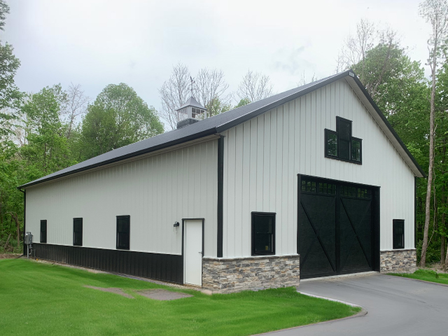 Custom post-frame building in Urbana Ohio with metal siding, overhead garage doors, and concrete driveway Custom post-frame building in Urbana Ohio with metal siding, overhead garage doors, and concrete driveway