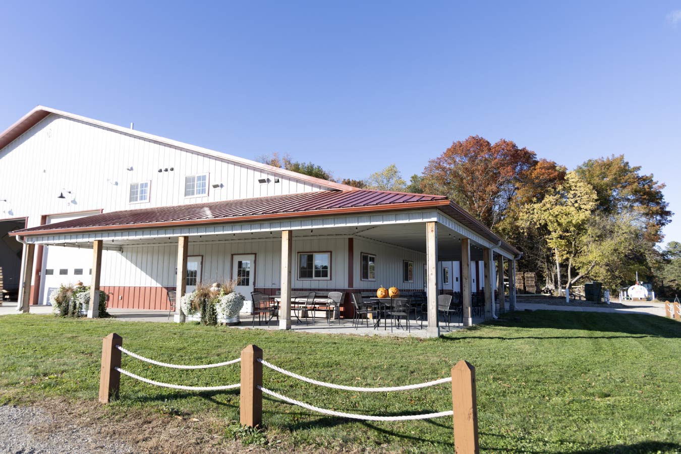 Timber-framed covered entry detail with decorative truss, black metal hardware, and red metal roof accents