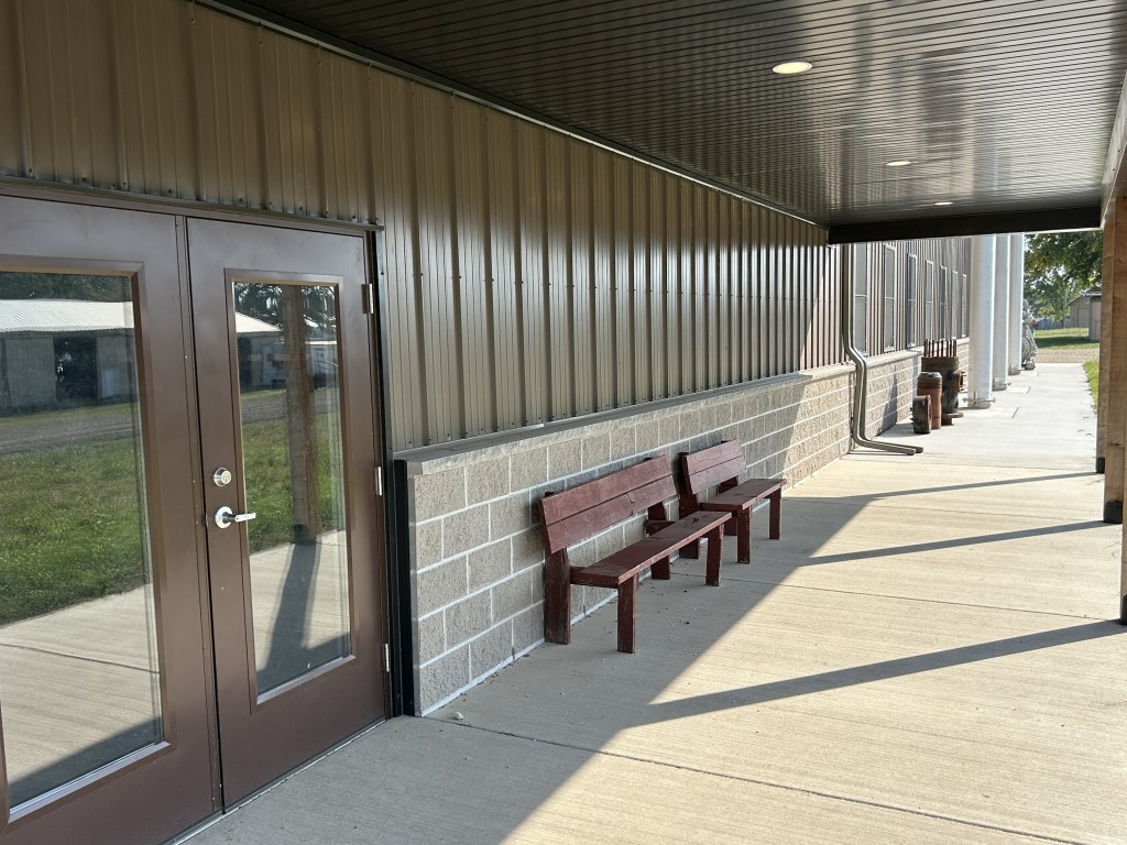 Baer Powerhouse Covered Porch and Glass Entry Doors Covered porch at the Baer Powerhouse with dual glass entry doors, bronze steel siding, stone wainscot, and concrete walkway.