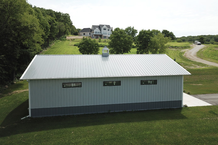 40×60 Backyard Pole Barn Garage with White Steel Siding | Walters Buildings 40x60 backyard pole barn garage with white steel siding, charcoal wainscot, and cupola