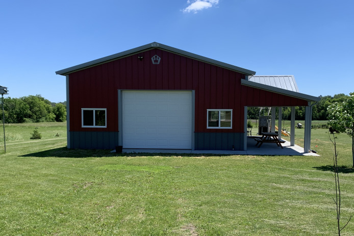 30×40 Garage with Covered Patio | Pole Barn Hobby Garage | Walters Buildings 30x40 red pole barn garage with white overhead garage door covered patio and gray steel wainscot