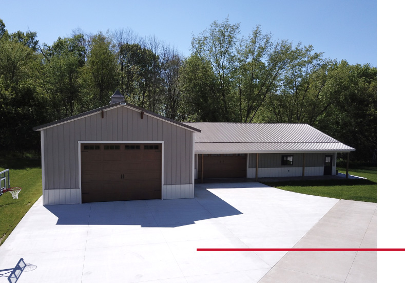 L shaped pole barn garage with large concrete driveway, covered workspace, and oversized garage door