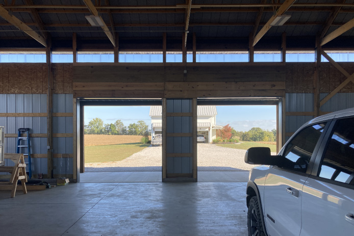 Interior of 40×64 post-frame pole barn with exposed wood trusses, vehicle storage, and open layout for equipment use Interior of 40x64 post-frame pole barn with exposed wood trusses, vehicle storage, and open layout for equipment use