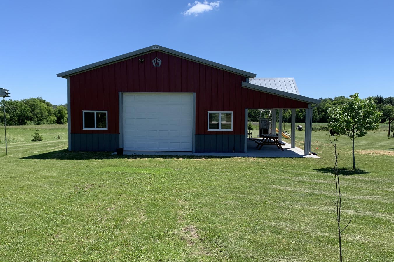 Project #94-0666 30x40 red pole barn garage with covered patio white overhead door and gray steel wainscot