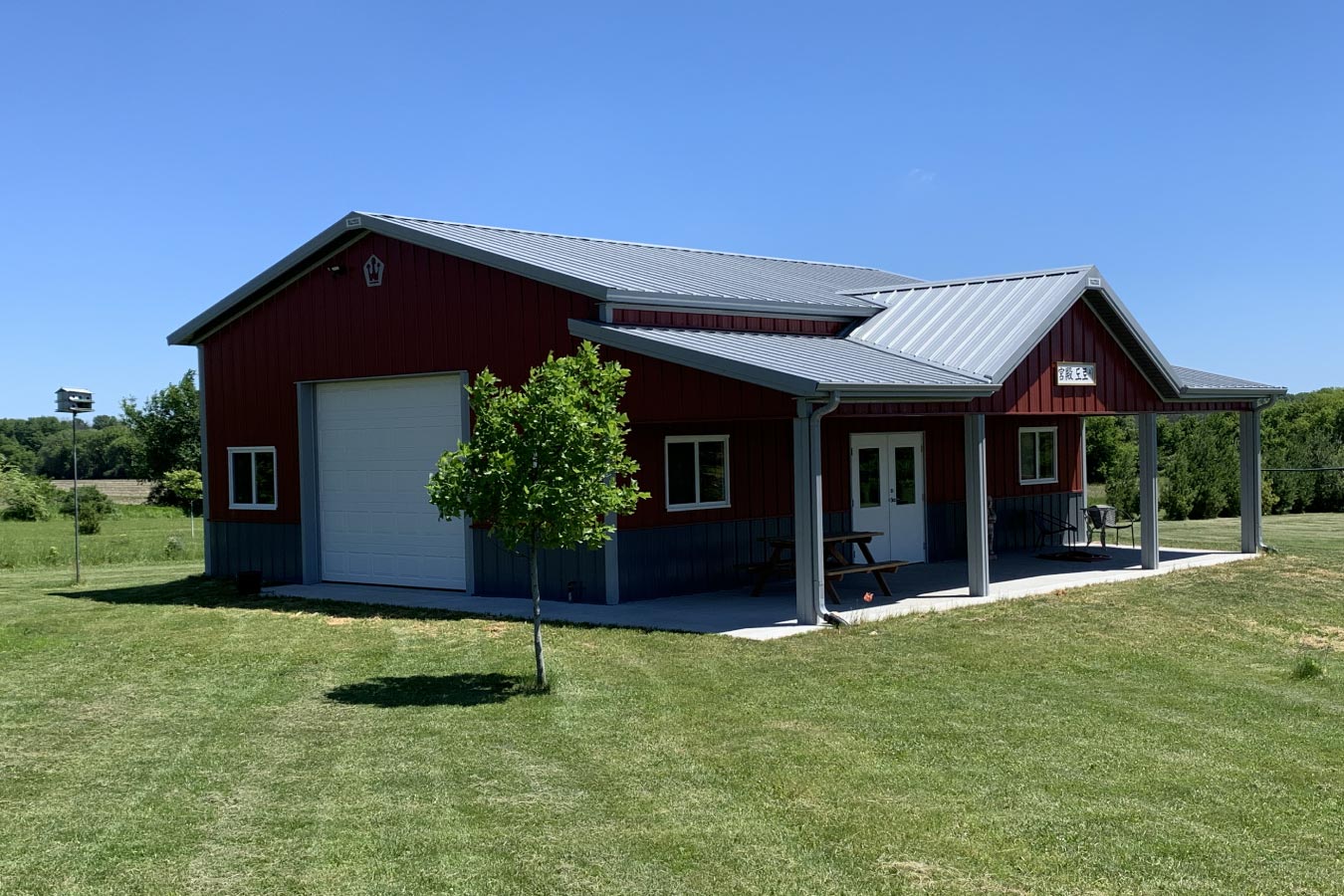 30x40 red pole barn garage with covered porch white steel roof and overhead garage door