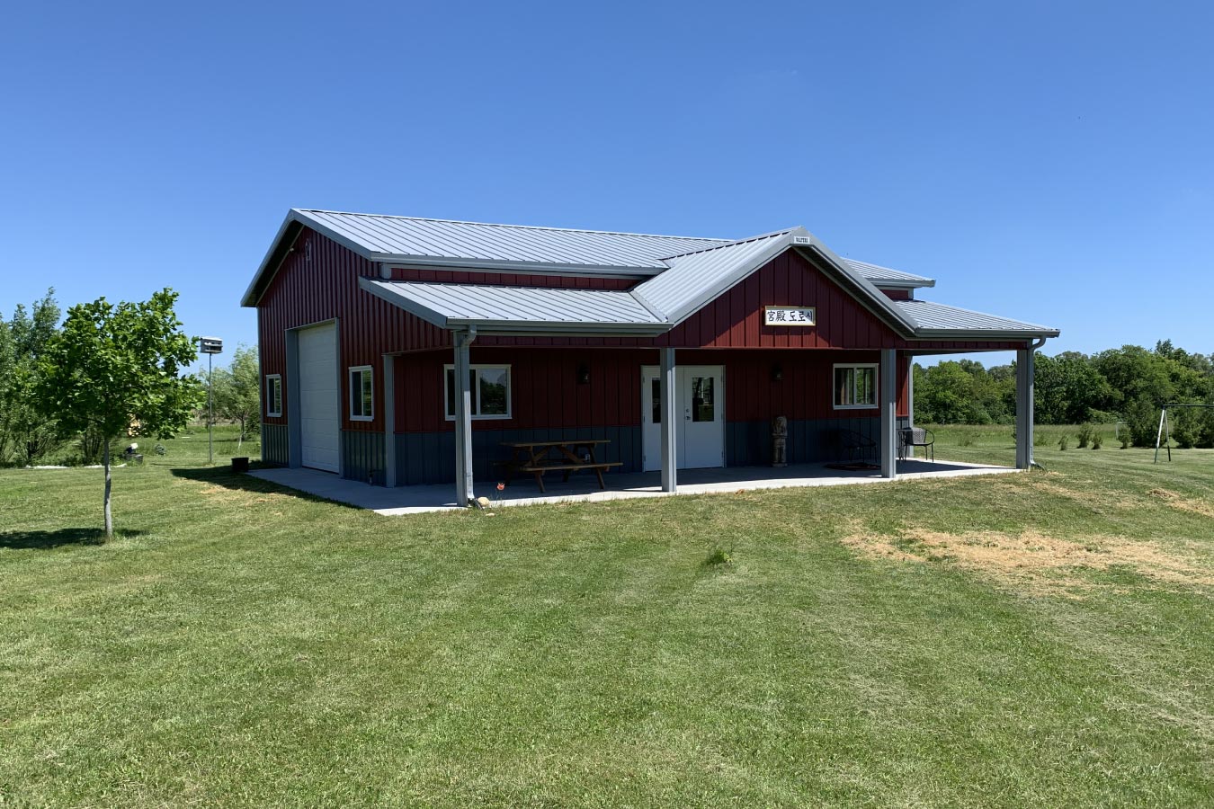 30x40 red pole barn garage with covered porch white steel roof and post frame construction