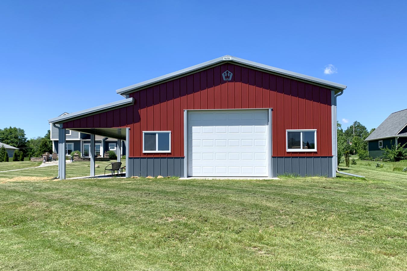30x40 pole barn garage with red steel siding white overhead garage door and gray wainscot