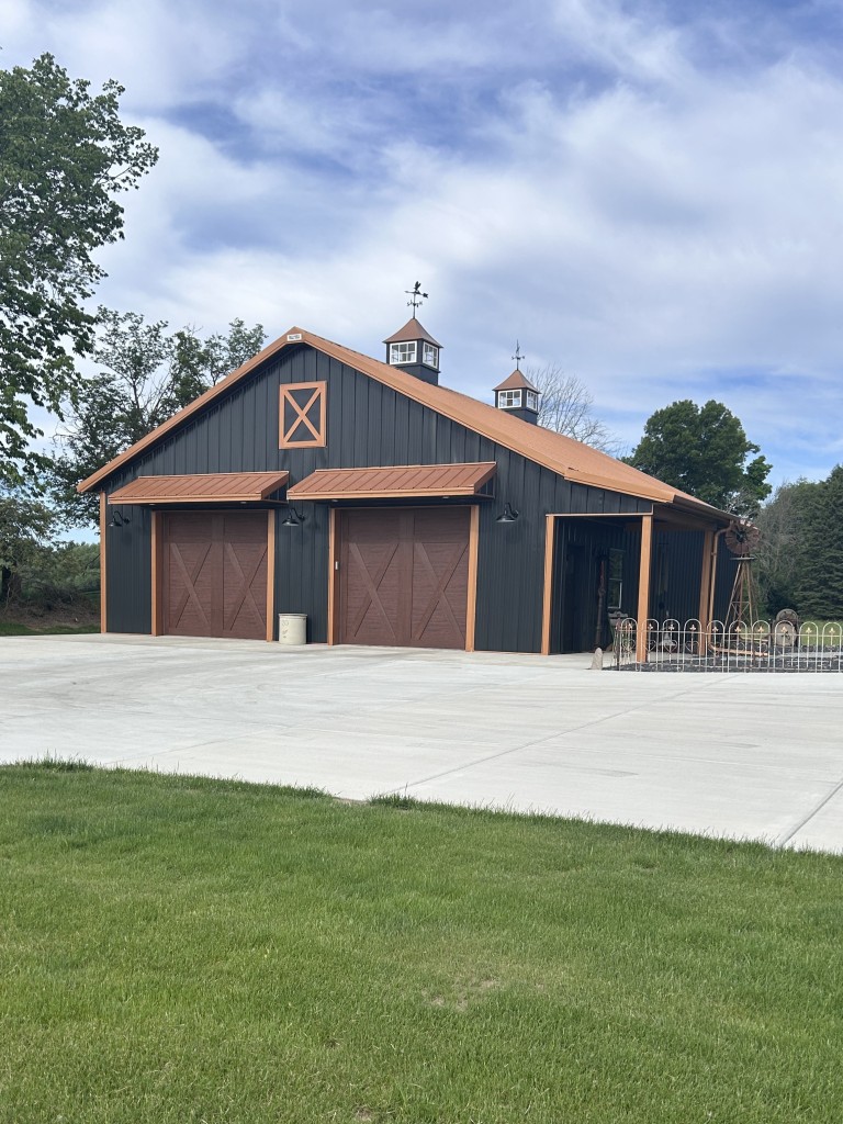 36×50 Metal Garage with Black Steel and Copper Trim 36x50 black metal garage with copper roof, copper trim, cupolas, Clopay garage doors, and side porch by Walters Buildings